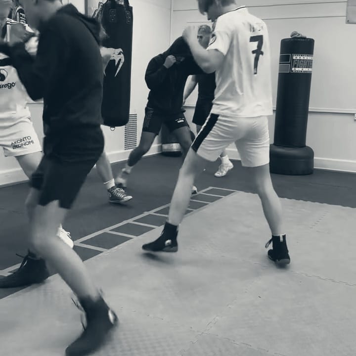 Flere boksere jobber med fotarbeid på en stige langs gulvet i klubblokalet